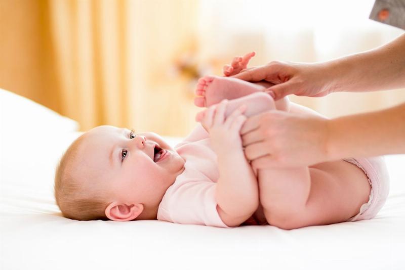 Hai người mẹ trẻ đang ngồi trò chuyện thân mật, chia sẻ kinh nghiệm nuôi con, có thể có một em bé đang chơi gần đó.
